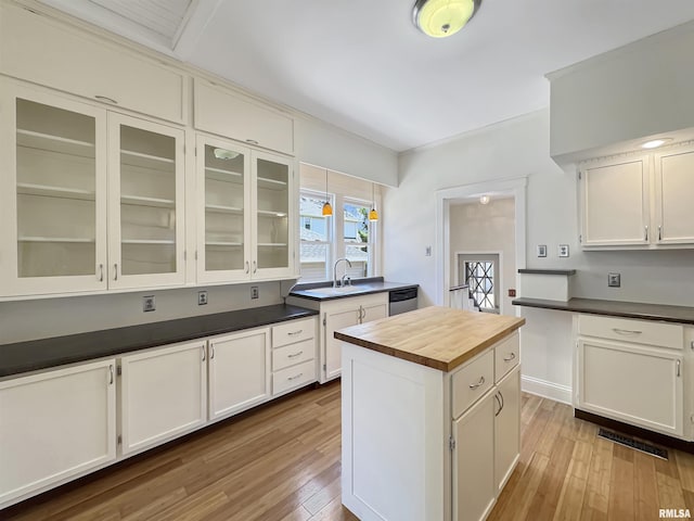 510 W Willcox Ave, Peoria, IL 61604 - kitchen with wooden counters, wood-type flooring, white cabinetry, glass insert cabinets, and a kitchen island