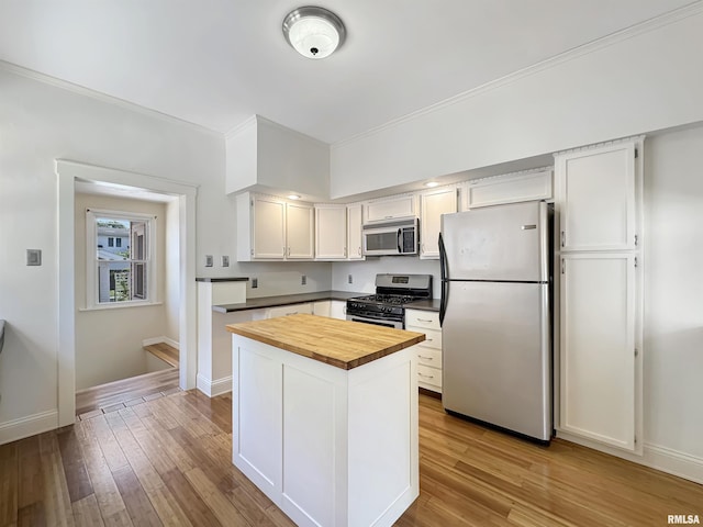 510 W Willcox Ave, Peoria, IL 61604 - kitchen with stainless steel appliances, wood counters, wood finished floors, white cabinetry, and ornamental molding