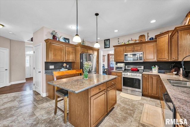 1712 Rustic Oak Dr, Washington, IL 61571 - kitchen featuring appliances with stainless steel finishes, brown cabinets, a center island, stone tile flooring, and recessed lighting