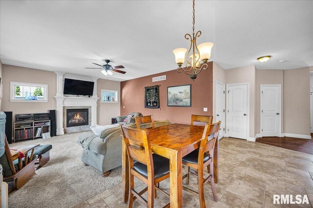 1712 Rustic Oak Dr, Washington, IL 61571 - dining room featuring a ceiling fan, a glass covered fireplace, a chandelier, and light stone finish flooring
