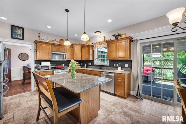 1712 Rustic Oak Dr, Washington, IL 61571 - kitchen featuring appliances with stainless steel finishes, stone tile floors, brown cabinets, light stone countertops, and recessed lighting
