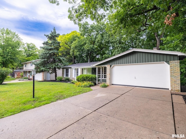 743 W Wonderview Dr, Dunlap, IL 61525 - view of front of house with brick siding, a front yard, an attached garage, and concrete driveway