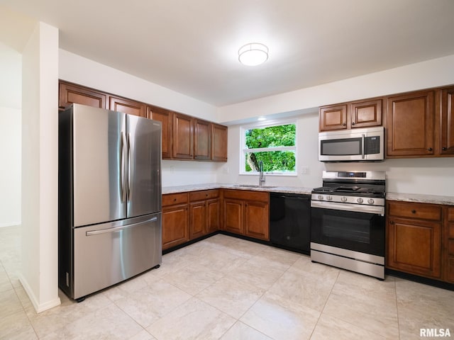 743 W Wonderview Dr, Dunlap, IL 61525 - kitchen with stainless steel appliances, brown cabinetry, light tile patterned floors, and light stone counters
