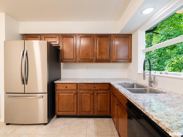 743 W Wonderview Dr, Dunlap, IL 61525 - kitchen featuring freestanding refrigerator, dishwasher, brown cabinetry, and light stone countertops