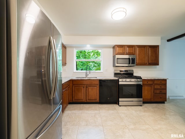 743 W Wonderview Dr, Dunlap, IL 61525 - kitchen featuring appliances with stainless steel finishes, brown cabinetry, light stone countertops, and light tile patterned flooring