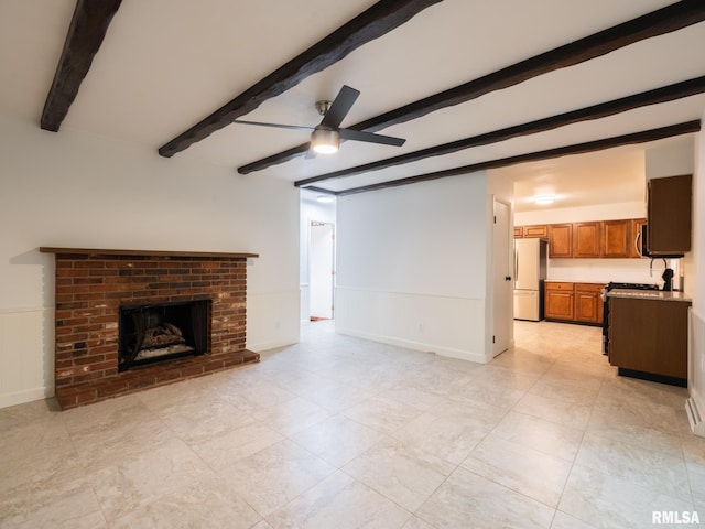 743 W Wonderview Dr, Dunlap, IL 61525 - unfurnished living room with beam ceiling, ceiling fan, a wainscoted wall, and a fireplace