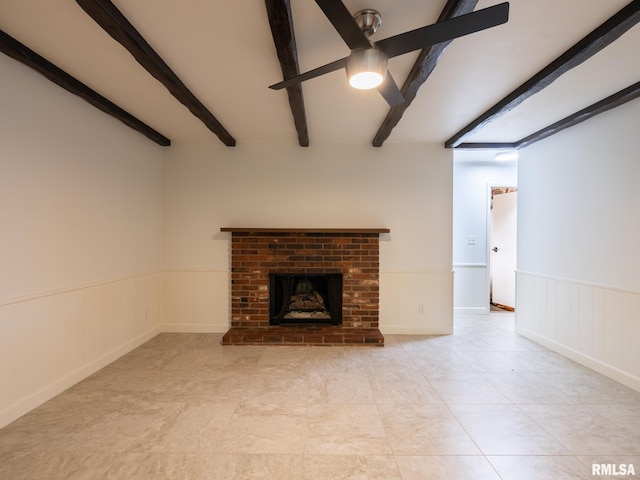 743 W Wonderview Dr, Dunlap, IL 61525 - unfurnished living room featuring ceiling fan, beam ceiling, a brick fireplace, a wainscoted wall, and light tile patterned floors