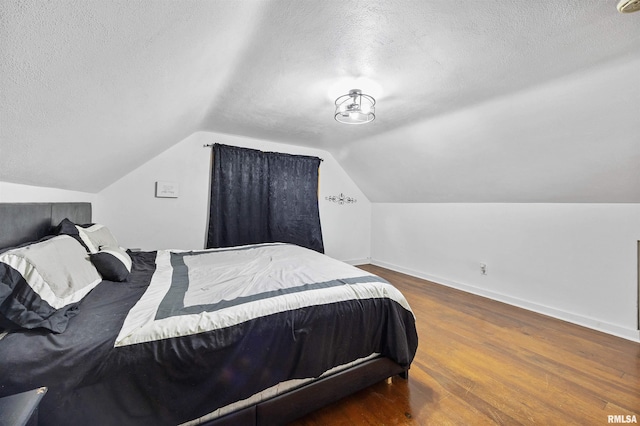 1900 S Airport Rd, Peoria, IL 61607 - bedroom featuring a textured ceiling, wood finished floors, and vaulted ceiling