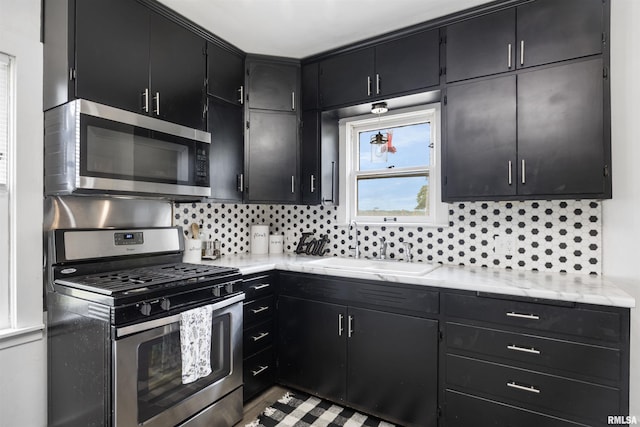1900 S Airport Rd, Peoria, IL 61607 - kitchen with appliances with stainless steel finishes, dark cabinetry, and tasteful backsplash