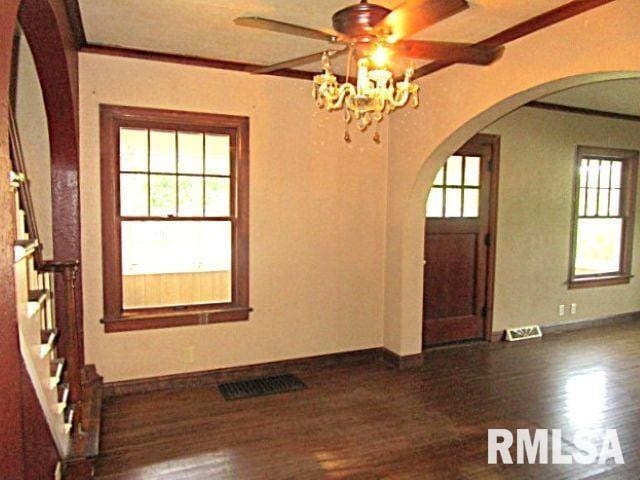320 E Meadow Lawn St, Manito, IL 61546 - foyer featuring arched walkways, dark wood finished floors, a chandelier, healthy amount of natural light, and crown molding