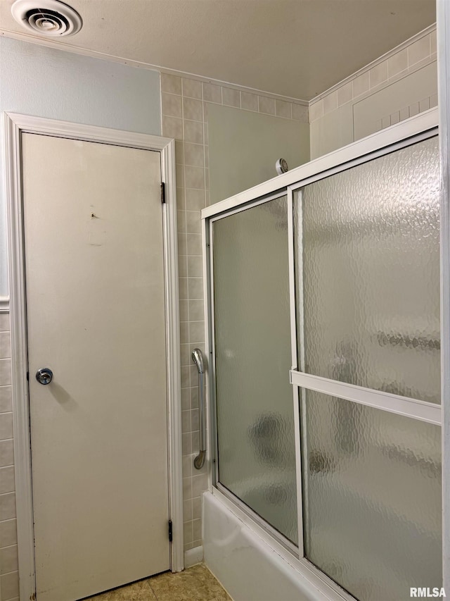 3813 W Brighton Ave, Peoria, IL 61615 - bathroom featuring shower / bath combination with glass door and tile patterned flooring