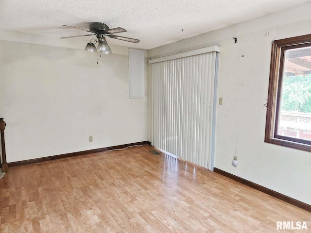 1003 Tonti Rd, Toulon, IL 61483 - spare room with light wood-style flooring, a textured ceiling, and ceiling fan