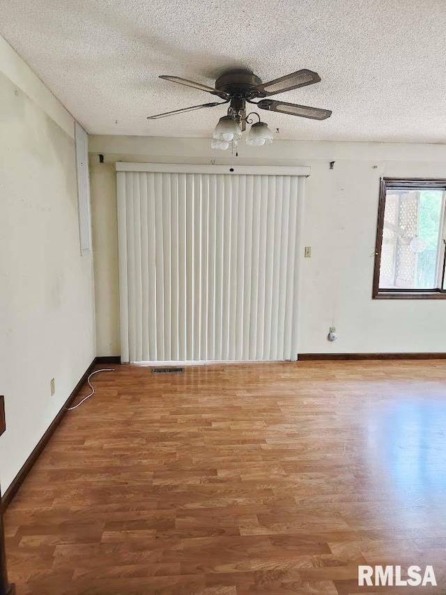 1003 Tonti Rd, Toulon, IL 61483 - spare room featuring wood finished floors, a textured ceiling, and ceiling fan