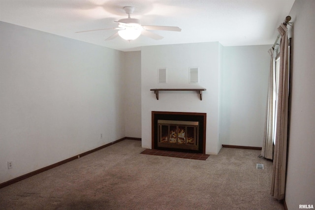1003 Tonti Rd, Toulon, IL 61483 - unfurnished living room featuring carpet flooring, ceiling fan, and a fireplace with flush hearth