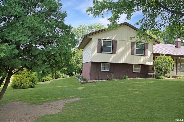 1003 Tonti Rd, Toulon, IL 61483 - view of side of home featuring brick siding, a lawn, and a chimney