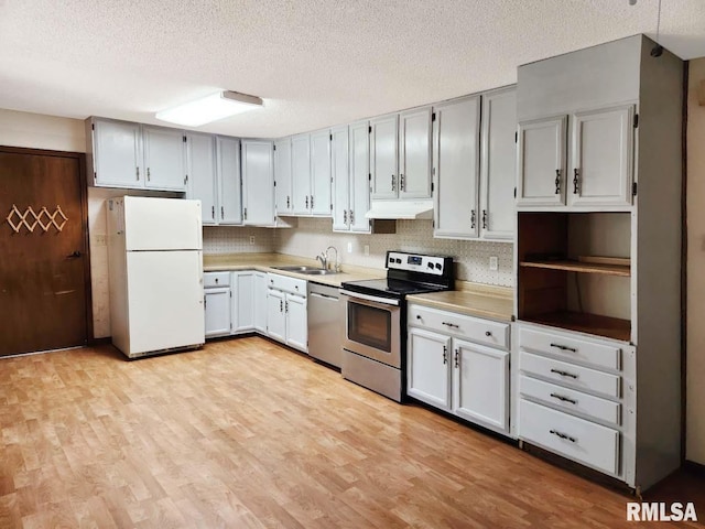 1003 Tonti Rd, Toulon, IL 61483 - kitchen featuring stainless steel appliances, a textured ceiling, light wood-style flooring, under cabinet range hood, and light countertops