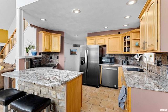 161 Lakecrest Pl, Dahinda, IL 61488 - kitchen featuring black appliances, a peninsula, a kitchen bar, backsplash, and light stone countertops
