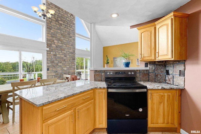 161 Lakecrest Pl, Dahinda, IL 61488 - kitchen with black electric range, a peninsula, light tile patterned flooring, light stone countertops, and lofted ceiling