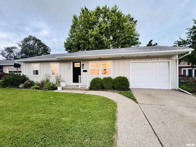 702 S Pearl St, Macomb, IL 61455 - ranch-style home featuring concrete driveway, board and batten siding, a front lawn, and an attached garage