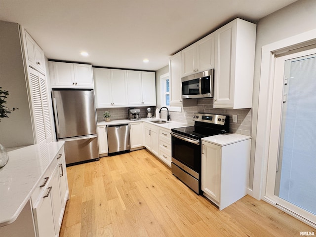 702 S Pearl St, Macomb, IL 61455 - kitchen with appliances with stainless steel finishes, light wood finished floors, backsplash, white cabinets, and recessed lighting