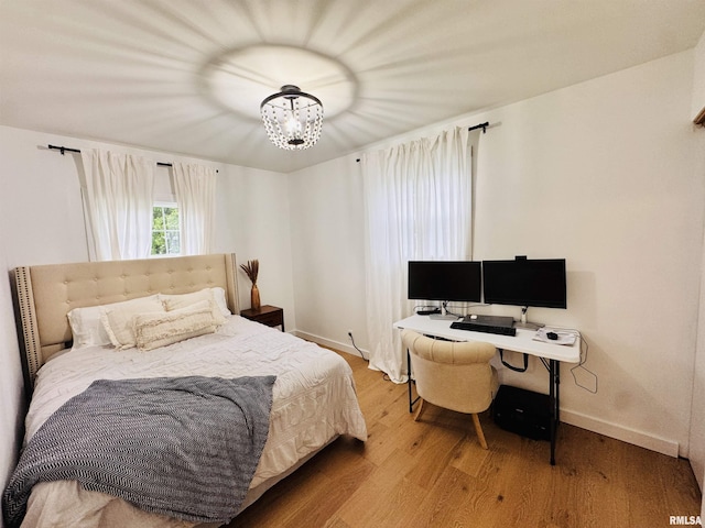 702 S Pearl St, Macomb, IL 61455 - bedroom with wood finished floors, a chandelier, and a desk