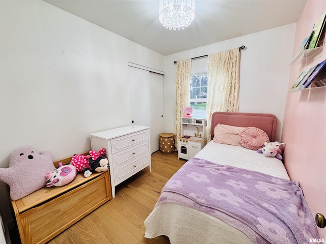 702 S Pearl St, Macomb, IL 61455 - bedroom with light wood-style floors, a chandelier, and a closet