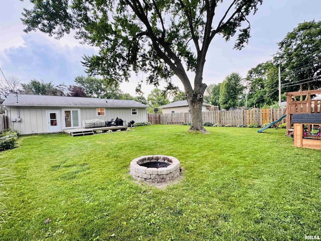 702 S Pearl St, Macomb, IL 61455 - fenced backyard featuring a playground, a fire pit, and a deck