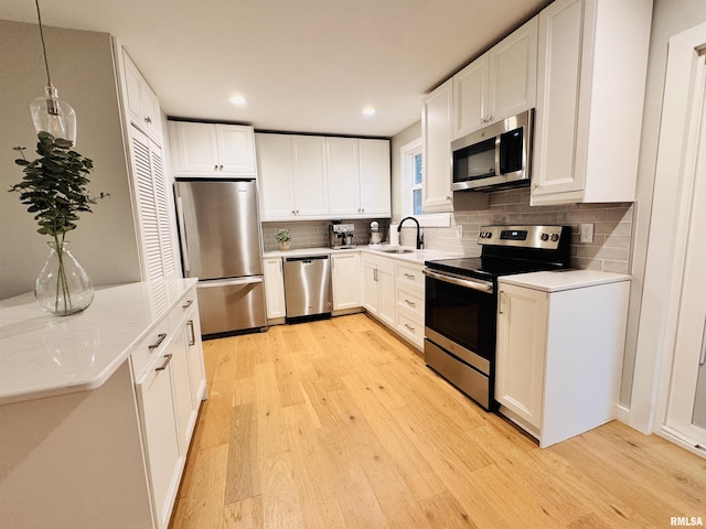 702 S Pearl St, Macomb, IL 61455 - kitchen with stainless steel appliances, light wood finished floors, tasteful backsplash, light countertops, and recessed lighting