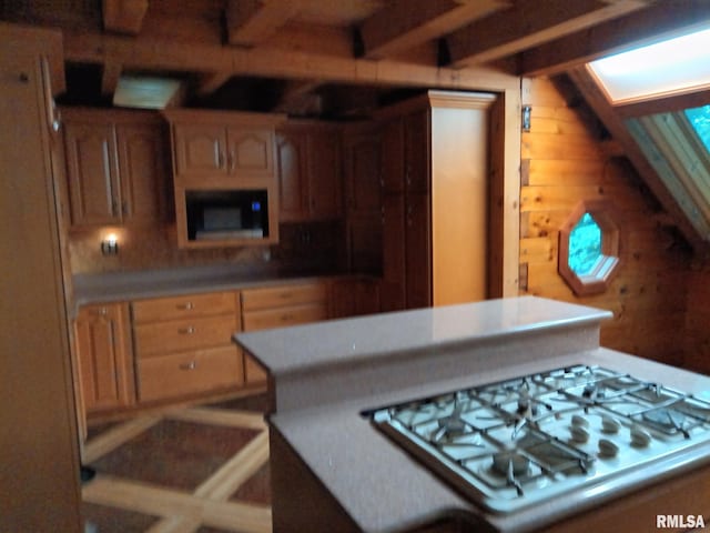 130 Zimmerman Rd, Spring Bay, IL 61611 - kitchen featuring white gas cooktop, beamed ceiling, wood walls, a skylight, and light countertops