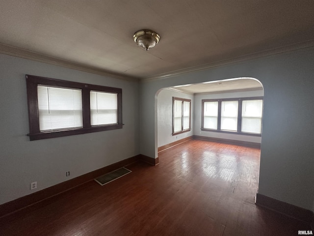 209 E Corrington Ave, Peoria, IL 61603 - empty room with arched walkways, ornamental molding, and dark wood finished floors