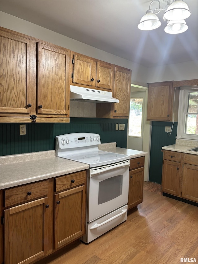626 N Main St, Lewistown, IL 61542 - kitchen with white electric range, under cabinet range hood, light countertops, and light wood finished floors