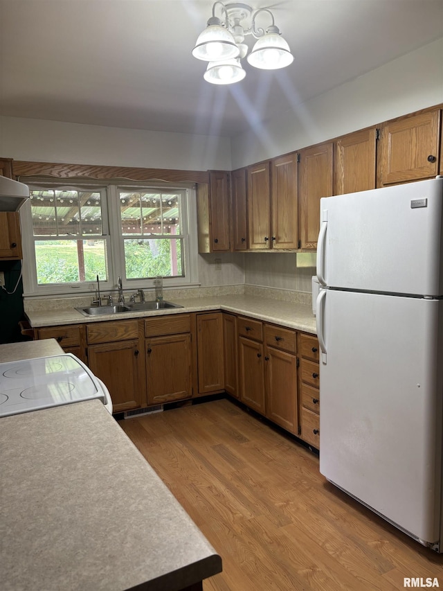 626 N Main St, Lewistown, IL 61542 - kitchen featuring freestanding refrigerator, brown cabinetry, stove, and light countertops