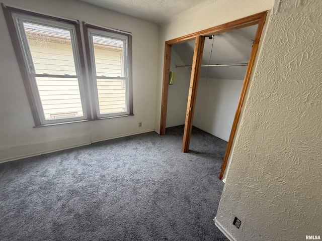 1712 W Bradley Ave, Peoria, IL 61606 - unfurnished bedroom with carpet flooring, a closet, and a textured wall