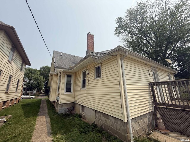 1712 W Bradley Ave, Peoria, IL 61606 - view of side of home featuring a chimney and a wooden deck