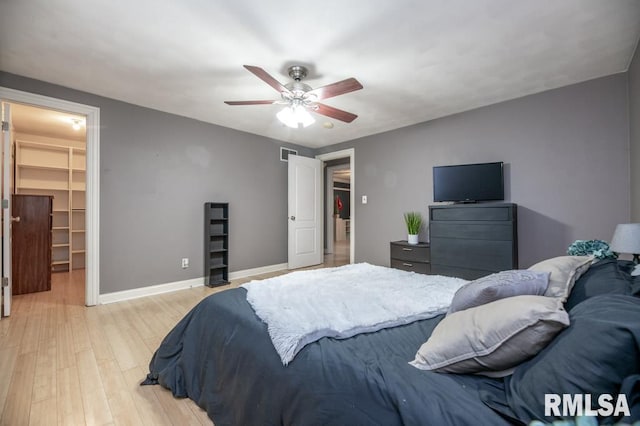 1200 Highview Rd, East Peoria, IL 61611 - bedroom with a walk in closet, light wood-style flooring, and ceiling fan