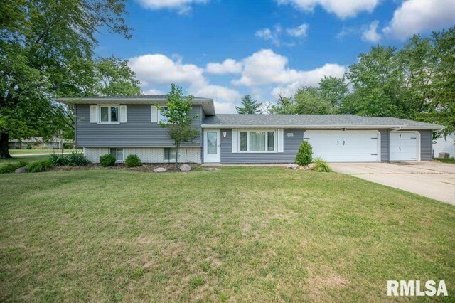 1200 Highview Rd, East Peoria, IL 61611 - split level home with concrete driveway, a garage, and a front yard