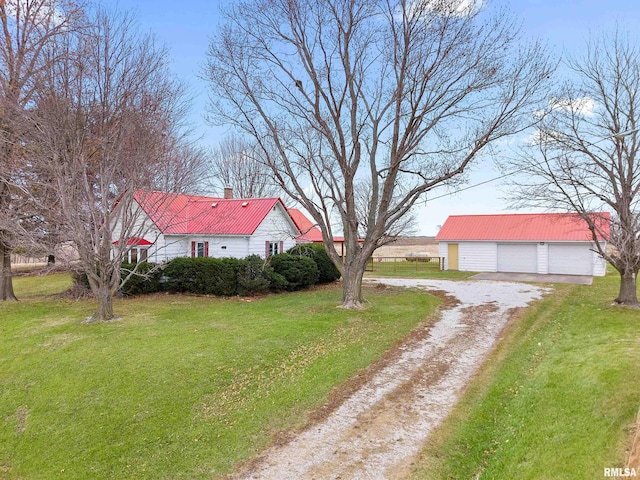 16905 E 1600th St, Bushnell, IL 61422 - view of property exterior featuring an outdoor structure, dirt driveway, a metal roof, a garage, and a lawn