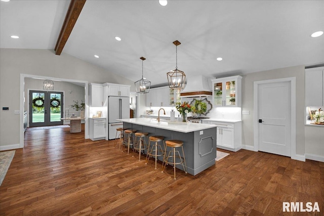 12804 W Dell Rd, Princeville, IL 61559 - kitchen with custom range hood, high end white refrigerator, light countertops, an island with sink, and dark wood-style flooring