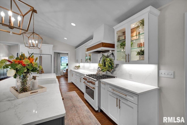 12804 W Dell Rd, Princeville, IL 61559 - kitchen featuring range with two ovens, custom exhaust hood, a chandelier, decorative backsplash, and white cabinetry