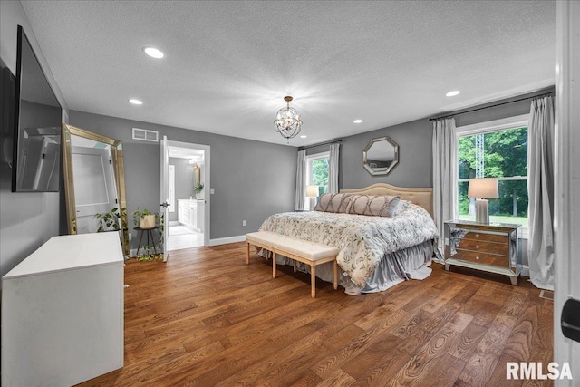 12804 W Dell Rd, Princeville, IL 61559 - bedroom with a textured ceiling, wood finished floors, a chandelier, multiple windows, and recessed lighting