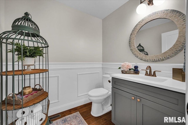 12804 W Dell Rd, Princeville, IL 61559 - half bath featuring vanity, wainscoting, wood finished floors, and a decorative wall