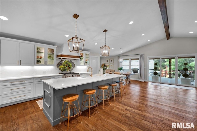 12804 W Dell Rd, Princeville, IL 61559 - kitchen with premium range hood, a kitchen breakfast bar, a center island with sink, dark wood-style floors, and light countertops