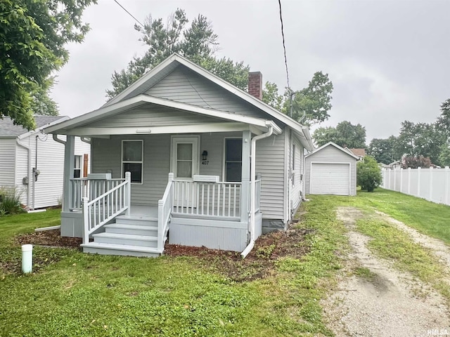 407 E Depot St, Knoxville, IL 61448 - view of front of house featuring a porch, dirt driveway, a garage, a chimney, and an outbuilding