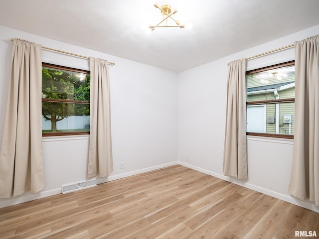 410 Stout Dr, Mackinaw, IL 61755 - empty room with light wood-style floors and a chandelier