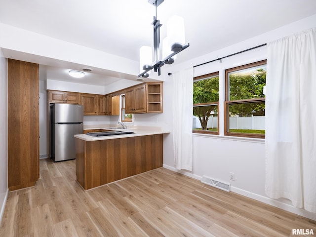 410 Stout Dr, Mackinaw, IL 61755 - kitchen with brown cabinetry, freestanding refrigerator, open shelves, light countertops, and a peninsula