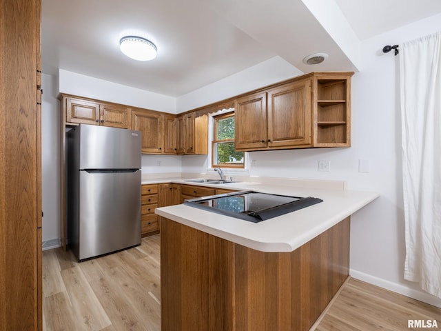 410 Stout Dr, Mackinaw, IL 61755 - kitchen featuring freestanding refrigerator, stovetop, a peninsula, brown cabinets, and light wood-type flooring