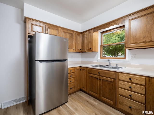 410 Stout Dr, Mackinaw, IL 61755 - kitchen featuring freestanding refrigerator, brown cabinets, and light wood-style flooring