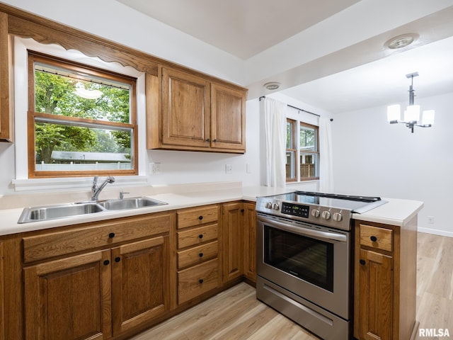 410 Stout Dr, Mackinaw, IL 61755 - kitchen with electric stove, a peninsula, brown cabinetry, light wood-style flooring, and light countertops