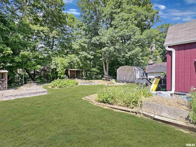 490 Oak Point Rd, Metamora, IL 61548 - view of green lawn with a storage unit and a garden