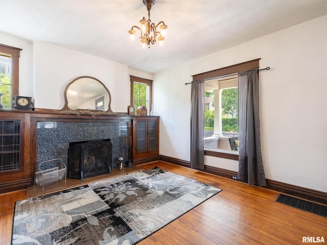 405 Washington St, Pekin, IL 61554 - living room featuring wood finished floors, plenty of natural light, a tile fireplace, and a chandelier